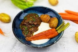 Kalfswangen gestoofd in rode wijn, met hasselback aardappeltjes, bloemkoolpuree en wortels