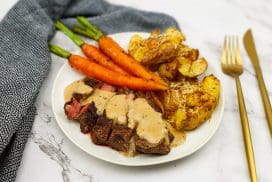 Ribeye steak met pepersaus, smashed potatoes en gebakken worteltjes