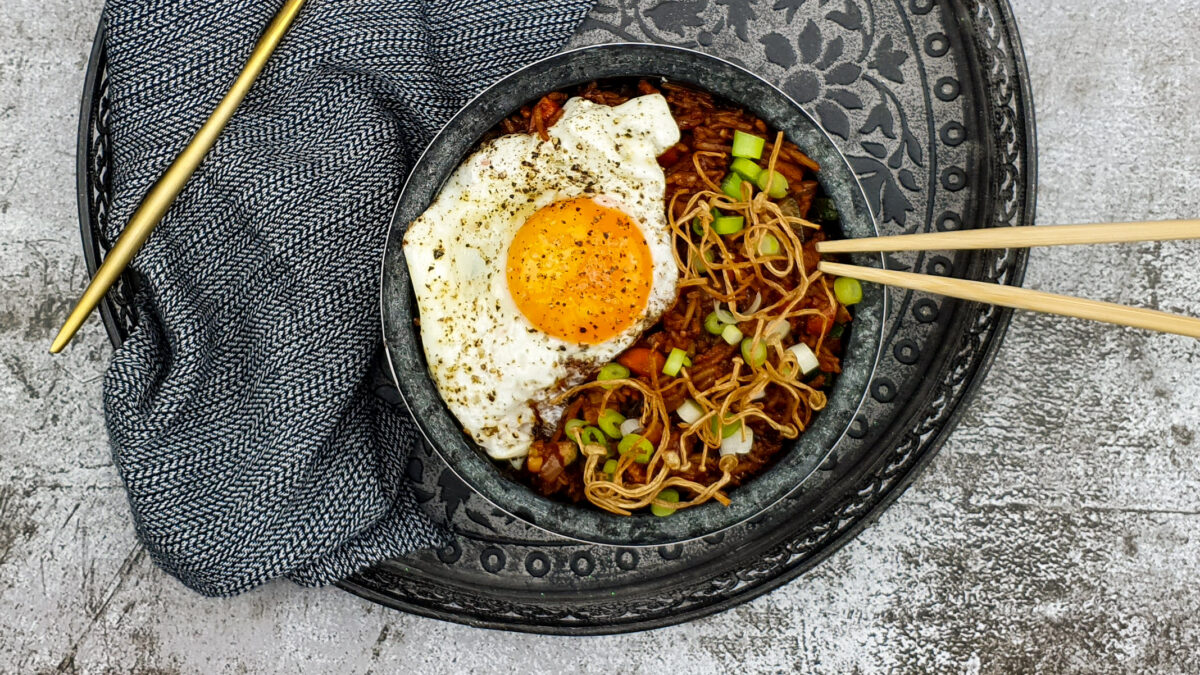 Koreaanse gebakken kimchi rijst met gefrituurde enoki en een gebakken eitje