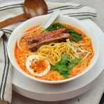 Singaporese laksa noodles van Prima Taste met entrecote en een zachtgekookt eitje
