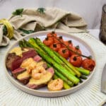 Ossenhaas tournedos met knoflookgarnalen roomsaus, gegrilde asperges en geroosterde tomaatjes