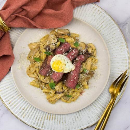Pasta met paddenstoelen, ribeye steak en een gebakken eitje