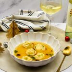 Tomatenconsommé met burrata tortellini, uitgebakken guanciale en basilicum olie