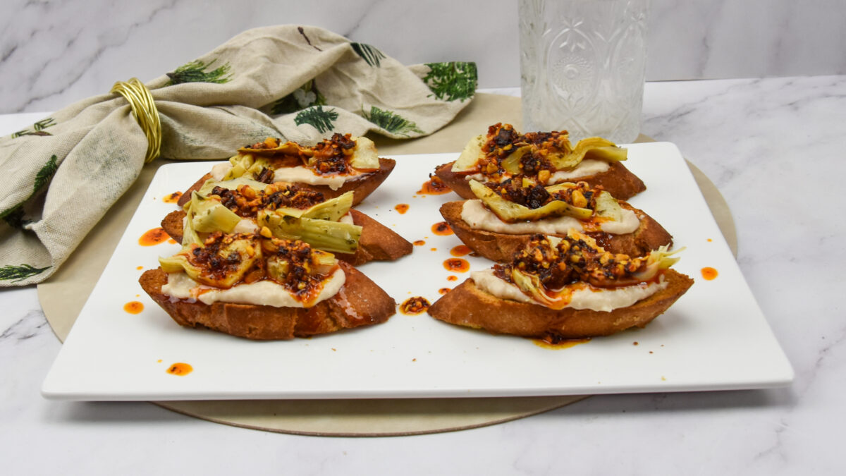 Crostini met witte bonenspread, artisjok en Italiaanse crispy chili oil