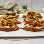 Crostini met witte bonenpuree en chili oil Crostini met witte bonenspread, artisjok en Italiaanse crispy chili oil